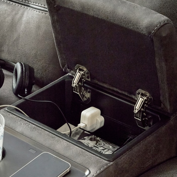 An open drawer with TV remote and changing cable inside