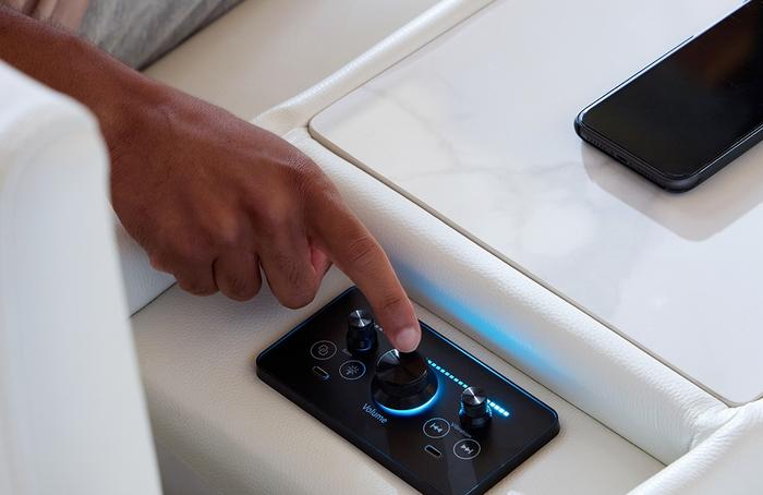hand reaching to a control panel for a sofa