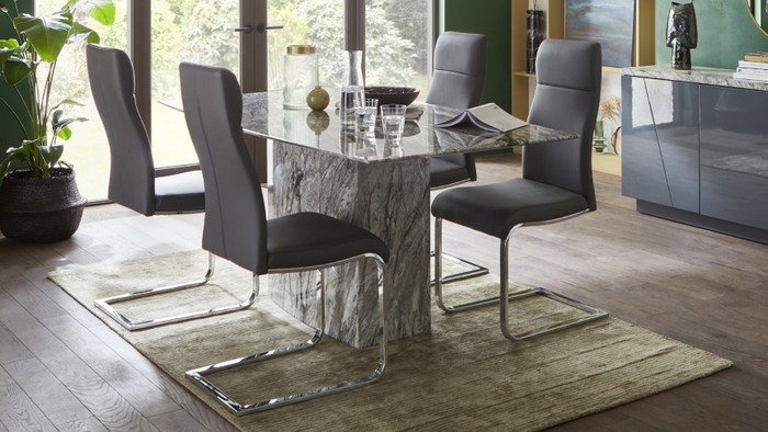 grey leather dining chairs under a glass dining table