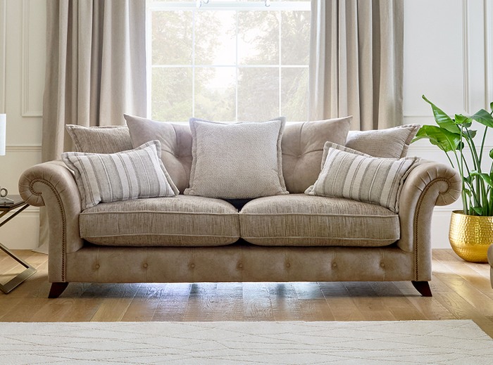 A beige chesterfield sofa with neutral accents