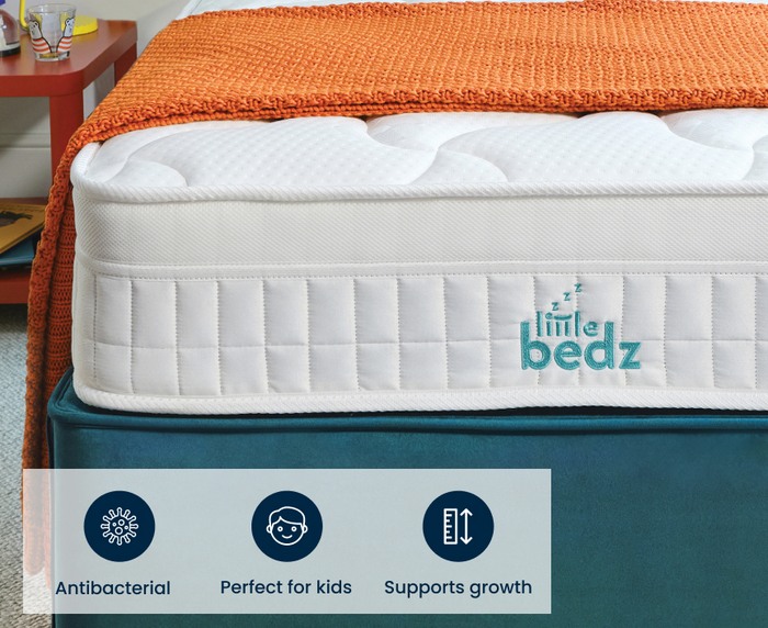 close up of a kids mattress on top of a teal divan bed 
