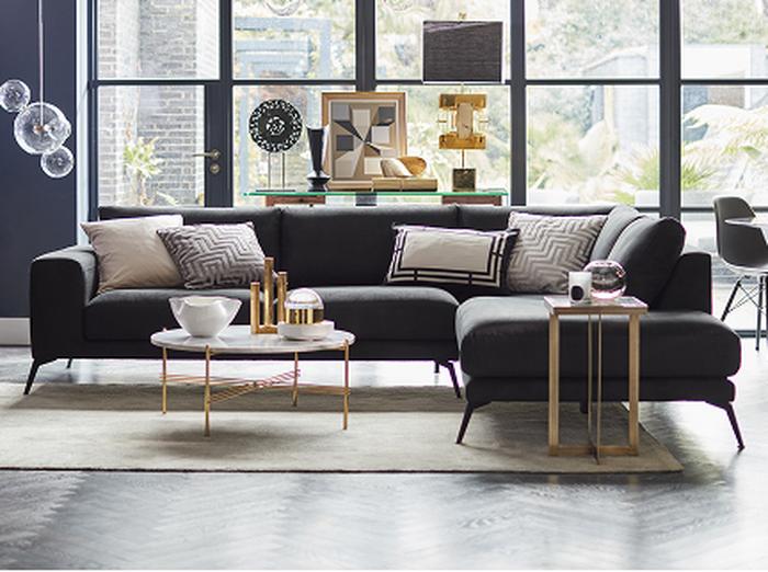 Black corner sofa with a cream rug