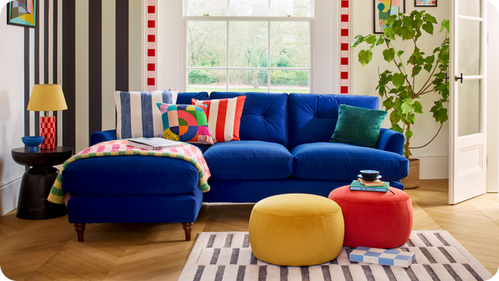 Blue Patterdale chaise sofa with bright accents and stripe backdrop