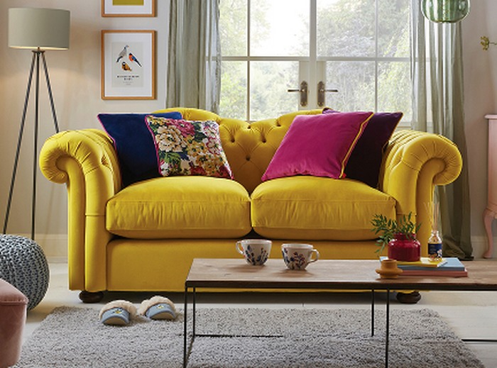 A velvet yellow sofa with colourful scatter cushion