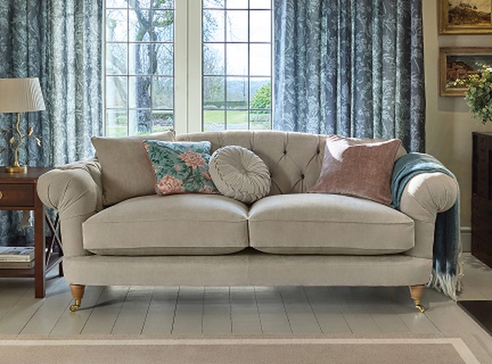 A cream chesterfield sofa with pastel accents