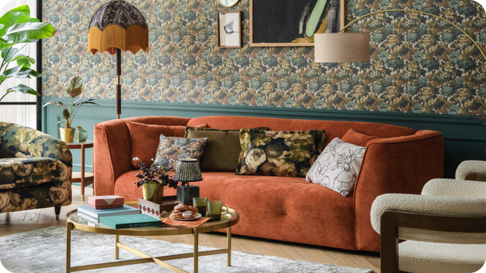 Orange curved sofa in a floral themed room 