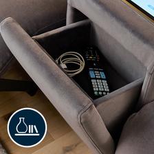 An open drawer with a charging cable and remote control