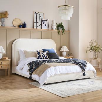 A white double bed in a coastal themed room