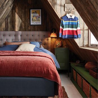 a pinstriped bed in a dark wood panelled room