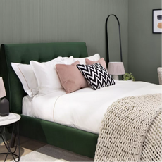Green bedframe with white sheets