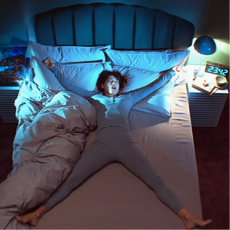 person sleeping in bed stretched out