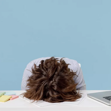 person with head restin on a desk