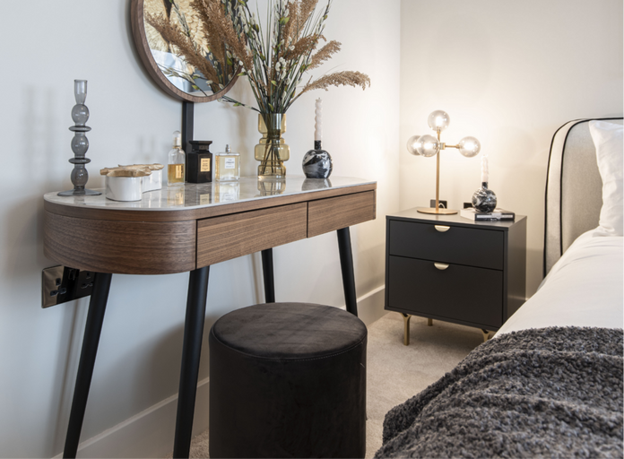 Dark wood console table with black legs topped with a vase and accessories 