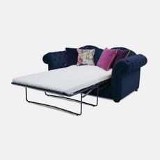 Dark blue Chesterfield sofa bed with pink and purple scatter cushions