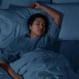 a young women sleeping on her back with her arm in the air