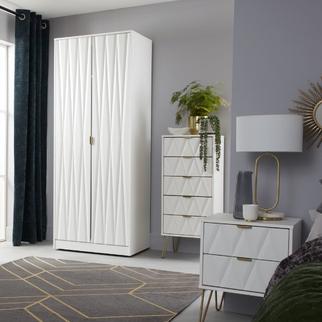 modern bedroom with white furniture featuring a tall wardrobe, sleek bedside table and tall chest of drawers
