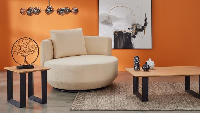 White swivel chair against a bright orange wall with wooden furniture with black metal legs