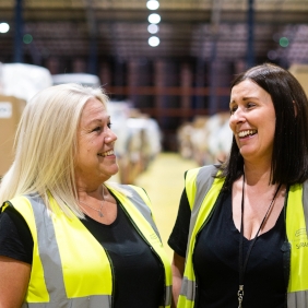Two women smiling in high vis vests