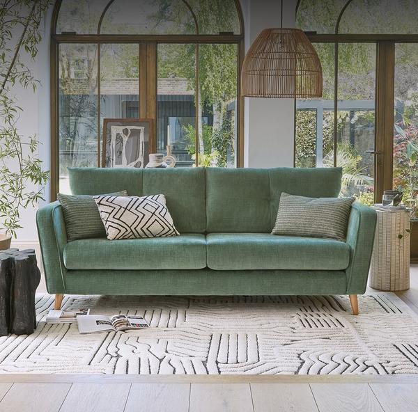 Mint green chenille sofa with geometric rug and scatter cushions