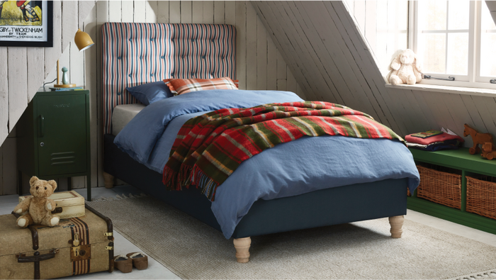 stylish kids bedroom with striped single bed and blue and plaid bedding and soft toys