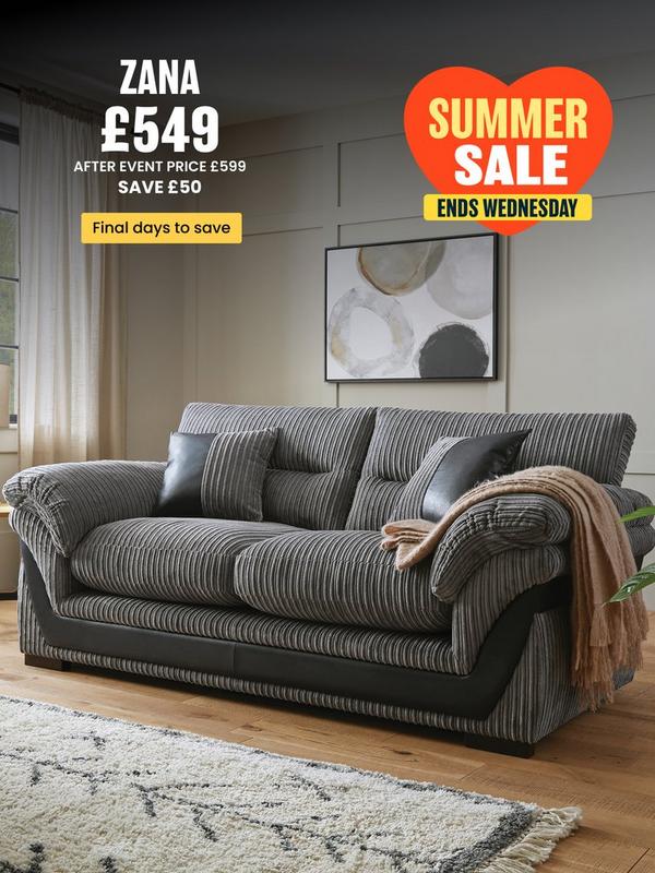 grey cord sofa with faux leather detailing on a wooden floored room setting