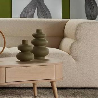 curved sofa with table and green vases
