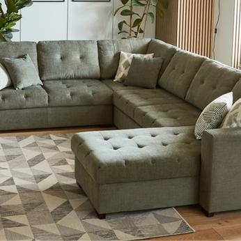 u shaped sofa in light olive green colour on a complimenting rug