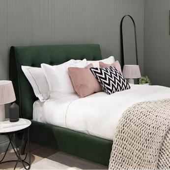 green bed with white bedding and pink cushions