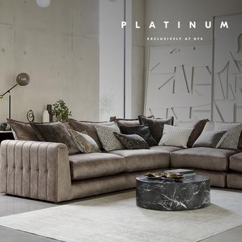 Brown leather sofa with quilted gold detailing in a large bright living space with a black marble coffee table
