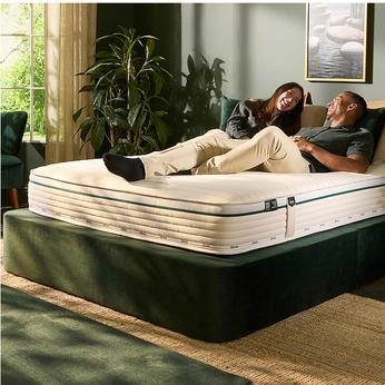 couple laughing on a green bed with a jaybe mattress