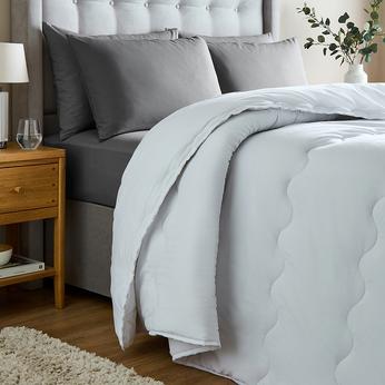close up of a bed with bedding draped over