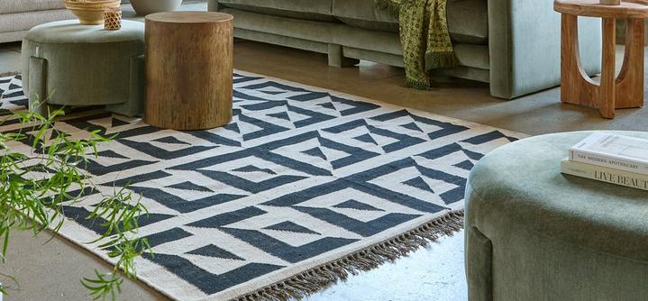 geometric design rug with footstool and wooden side tables 