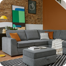 grey corner sofa with monochrome and orange scatter cushions