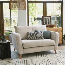 French Connection Carlisle cuddler chair with green and patterned scatter cushions and a green patterned rug