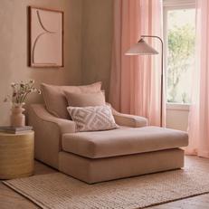 House Beautiful Maura cuddler chaise in natural in a calming living space with pink curtains and a neutral side table