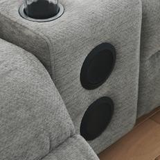 Two speakers connected by bluetooth on a light grey fabric sofa