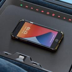 Iphone charging on a wireless charging plate on a corner smart sofa