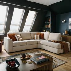 cream corner sofa in a dark room with brown and orange scatters