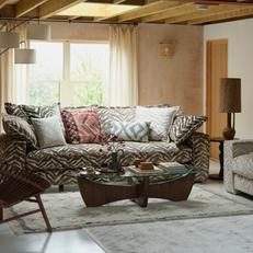 zebra print sofa with patterned scatter cushions next to a walnut coffee table with glass top