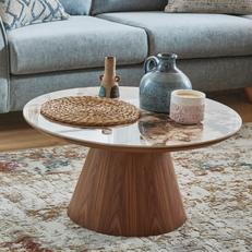 walnut round coffee table with brown mable effect top finished with ornaments and a patterened rug