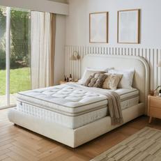 White boucle divan bed with a mattress finished with neutral bedding and a panelled wall