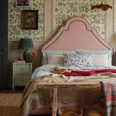 Joules Thornton Pink bed against a green floral wall and patterned accents