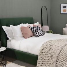 Green bed with light coloured bedding
