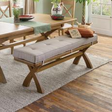 Dark wood dining bench with cream buttoned cushion on a cream rug