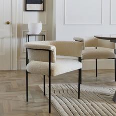 White boucle dining chair with rounded back with black metal legs