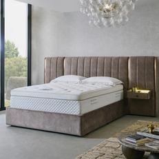 Mattress on a neutral hotel style bed with gold detailing