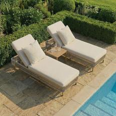 Neutral rattan style sunloungers next to an outdoor pool