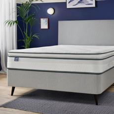 Light grey divan bed next to a navy blue wall with a Silentnight mattress