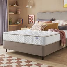 Beige divan bed with scalloped headboard and a Silentnight mattress next to a pale pink wall
