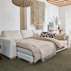 White sofa bed with light oak feet with a monochrome patterned scatter
